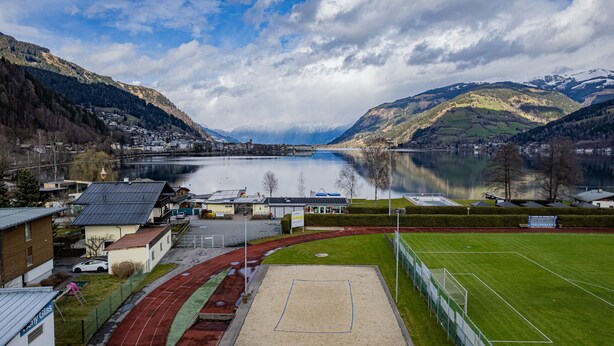 En vy över en stad vid en sjö, med en löparbana och en fotbollsplan.