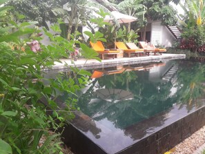Una piscina al aire libre, sombrillas