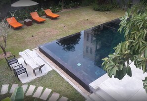 Una piscina al aire libre, sombrillas