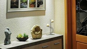 Un baño con lavamanos, espejo y un cuadro enmarcado encima.