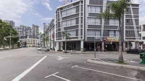 Un hôtel à plusieurs étages, au design moderne, surmonté d’un drapeau.