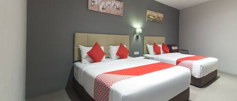 Ein Hotelzimmer mit zwei Betten, jeweils mit weißer Bettwäsche und roten Akzenten, einer grauen Wand und einem Gemälde über den Betten.