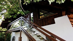 Een houten chalet met een glazen trap naar een balkon.