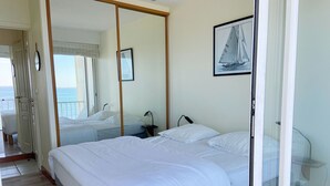 Una camera da letto con un letto grande, un comodino, uno specchio e un quadro appeso al muro.