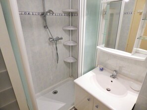 A bathroom with a shower, a sink, and a mirror.