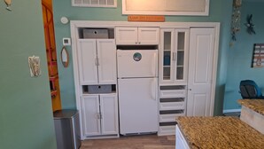 A compact kitchen with white cabinets, a built-in refrigerator, and a granite countertop. - REEL Paradise! <br>*Perfect Couple's Retreat or Big Fun For A Small Family* (Corpus Christi)
