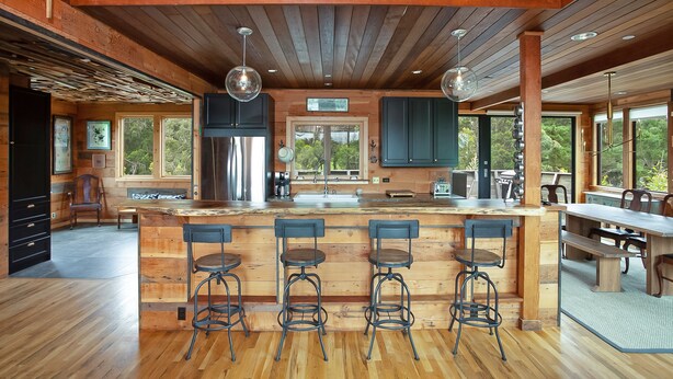 A spacious kitchen with a wooden island, bar stools, and large windows. - Country Home in Bolinas (Bolinas)