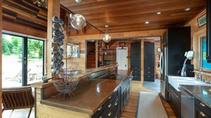 A modern kitchen with a large island, wooden cabinetry, and pendant lighting. - Country Home in Bolinas (Bolinas)