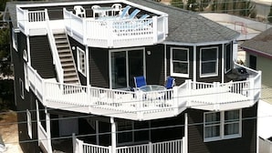 A multi-level house with a balcony, stairs, and outdoor seating.