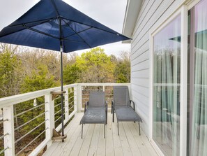 A covered outdoor seating area with two chairs and a large umbrella.