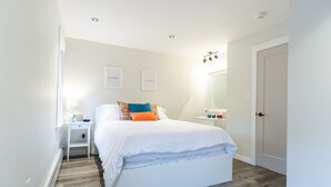 Ein Schlafzimmer mit Bett, Nachttisch und Spiegel.