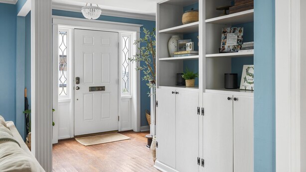 A hallway with a white door, a white cabinet with shelves, and a blue wall. - Private Courtyard + Steps from King St +Parking Included (Charleston)