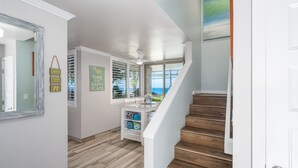 A staircase with wooden steps leading to a landing with a view of the ocean.