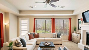 A living room with a sectional sofa, a coffee table, a fireplace, and a television. - Red Cliffs PET FRIENDLY! (Washington)