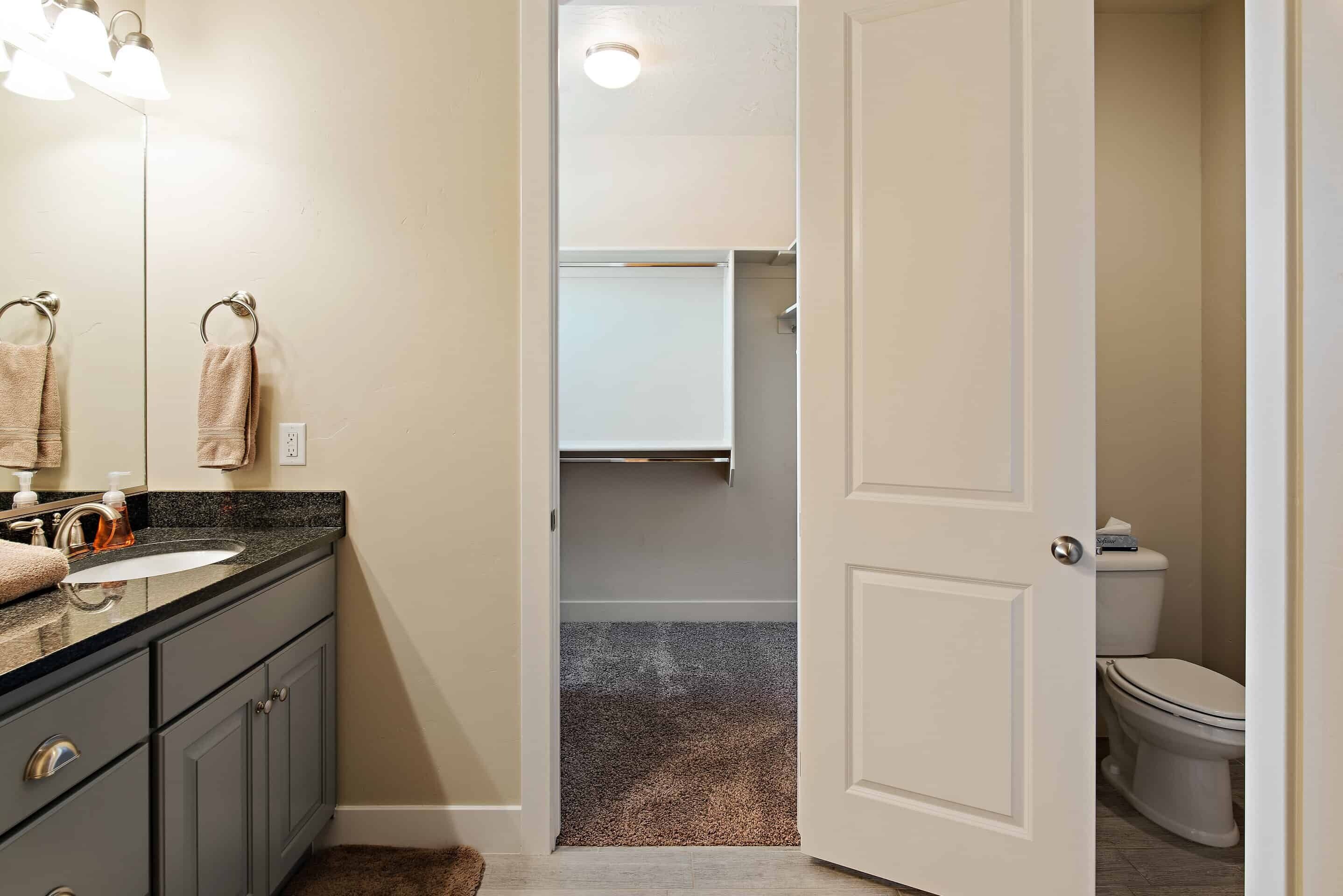 A bathroom with a sink, mirror, towel rack, and toilet.