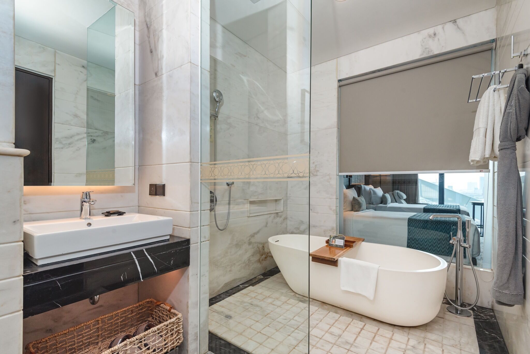 A modern bathroom with a freestanding bathtub, a glass-enclosed shower, and a vanity with a marble countertop.