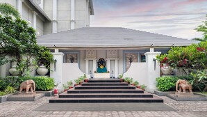 A building with a tiled roof, a statue of an elephant at the entrance, and steps leading to a door. - Pramod Convention & Beach Resort (Puri)