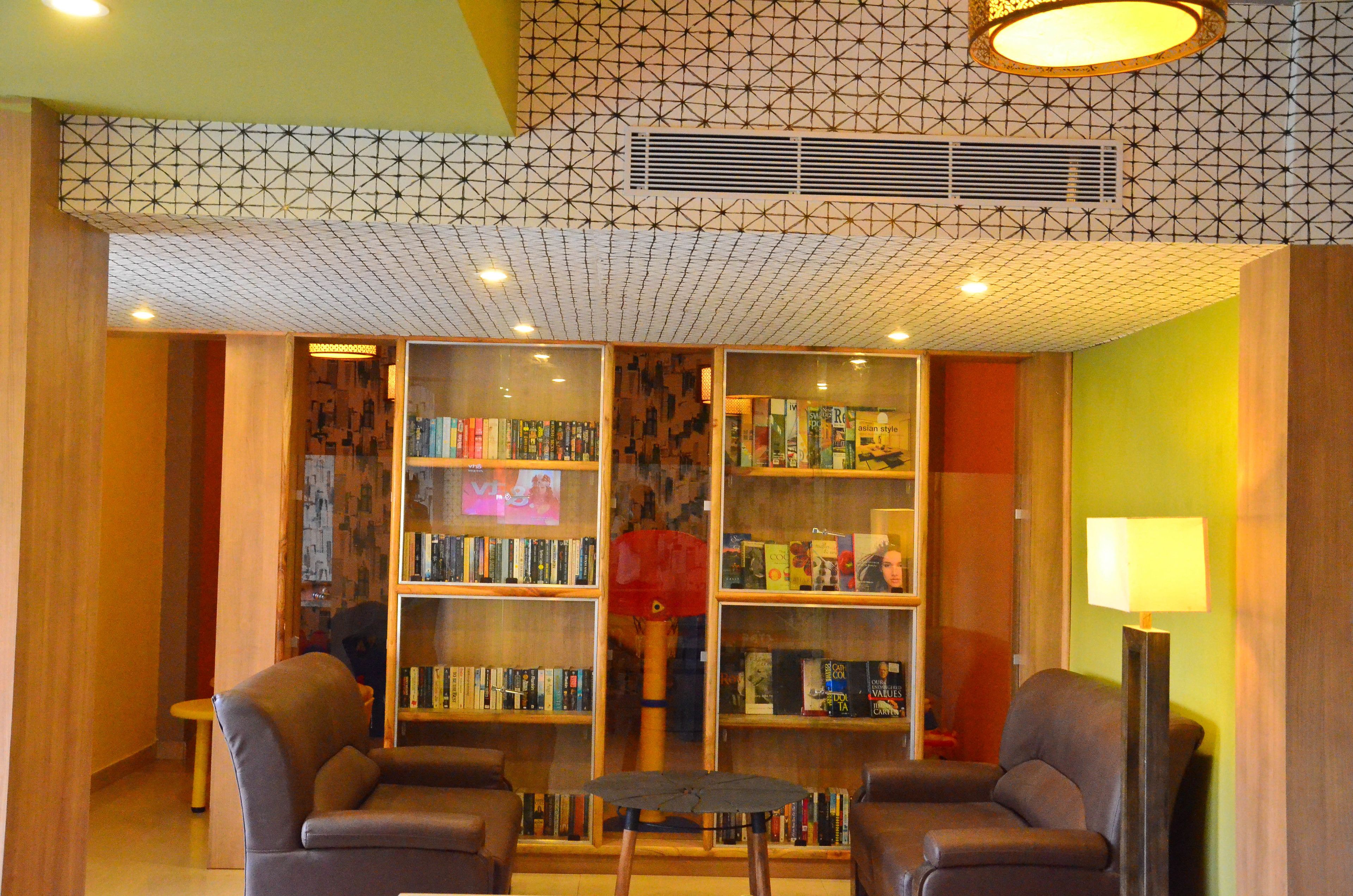 Una biblioteca con estanterías, dos sillones y una pequeña mesa.