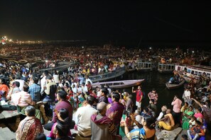 A crowded riverside area with numerous boats and people gathered around. - Tara Guest House (Varanasi)
