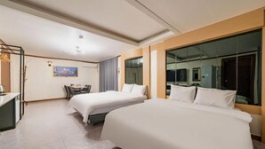 Une chambre d’hôtel avec deux lits, un bureau et une chaise.