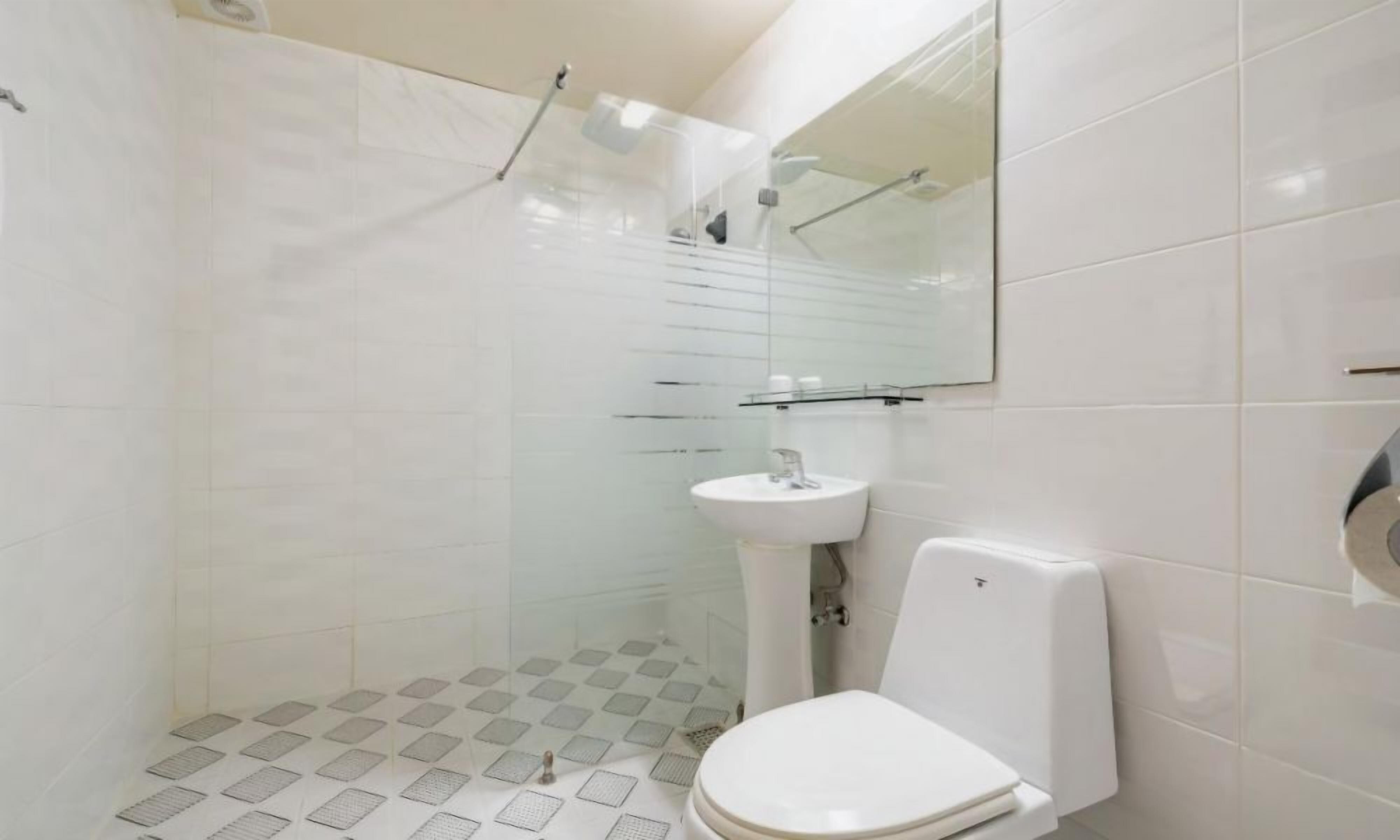 Un baño moderno con ducha, lavamanos e inodoro.