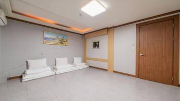 Una habitación de hotel con una cama grande, una puerta de madera y una lámpara en el techo.