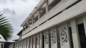 Un edificio con facciata bianca, pannelli decorativi e tetto rosso.