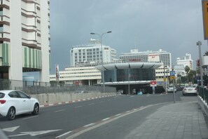 En modern byggnad med en böjd fasad, en parkeringsskylt och en gångväg för fotgängare.