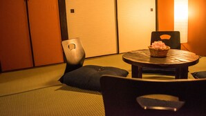 A traditional Japanese room with tatami flooring, a low table with a basket, and a chair. - Oyado Toji 3 (Kyoto)