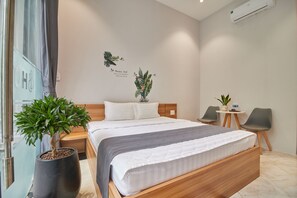 A hotel room with a bed, two chairs, a small table, and a potted plant. - Bin Bin Hotel 2 - Near Him Lam D7 (Ho Chi Minh City)