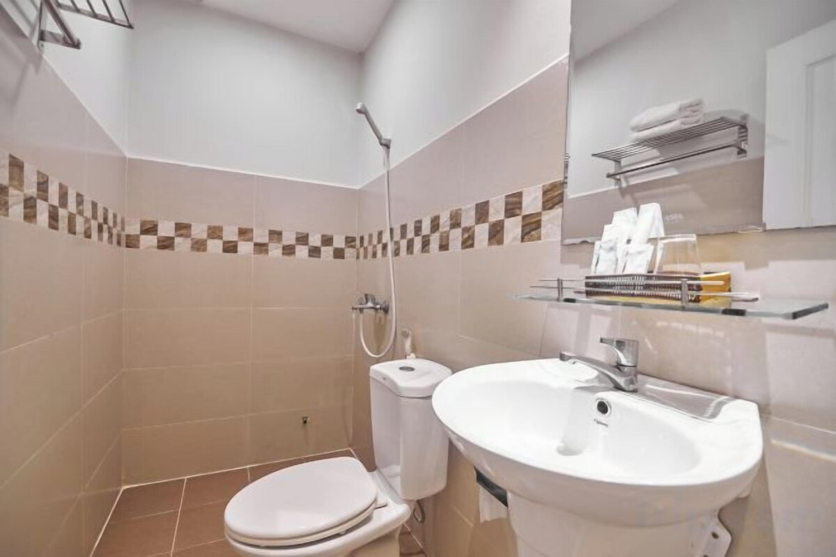 A bathroom with a toilet, sink, and shower.