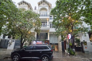 A hotel entrance with a black SUV parked in front, a reception desk, and a sign indicating the hotel name. - Bin Bin Hotel 2 - Near Him Lam D7 (Ho Chi Minh City)