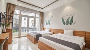 A hotel room with two beds, a desk, and a balcony with a view of buildings. - Bin Bin Hotel 2 - Near Him Lam D7 (Ho Chi Minh City)