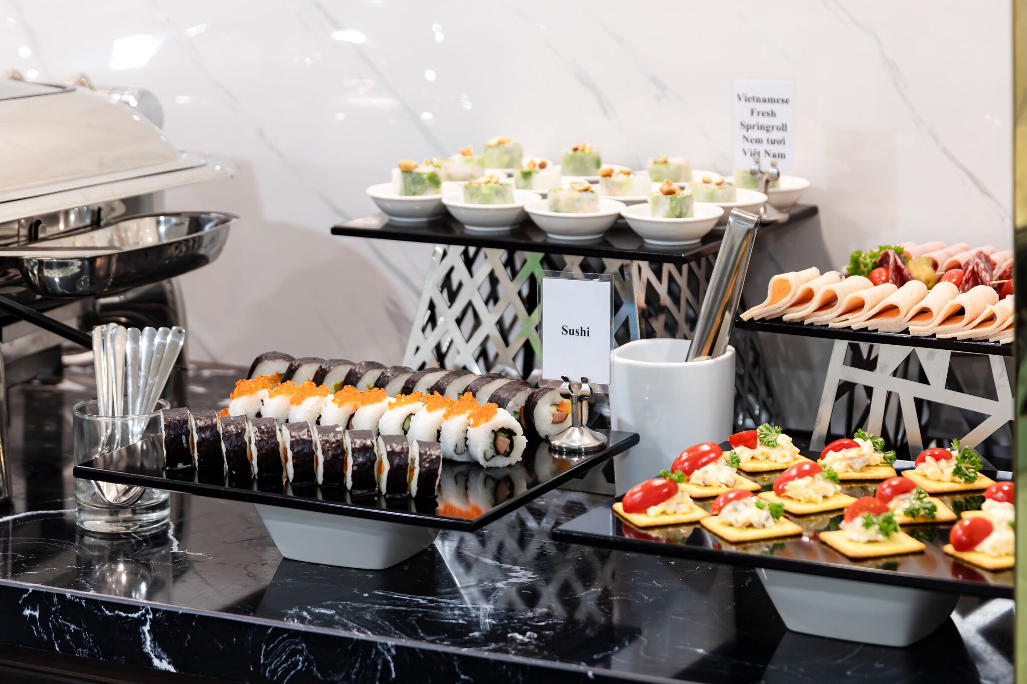 A buffet with various food options including sushi, spring rolls, and other appetizers.