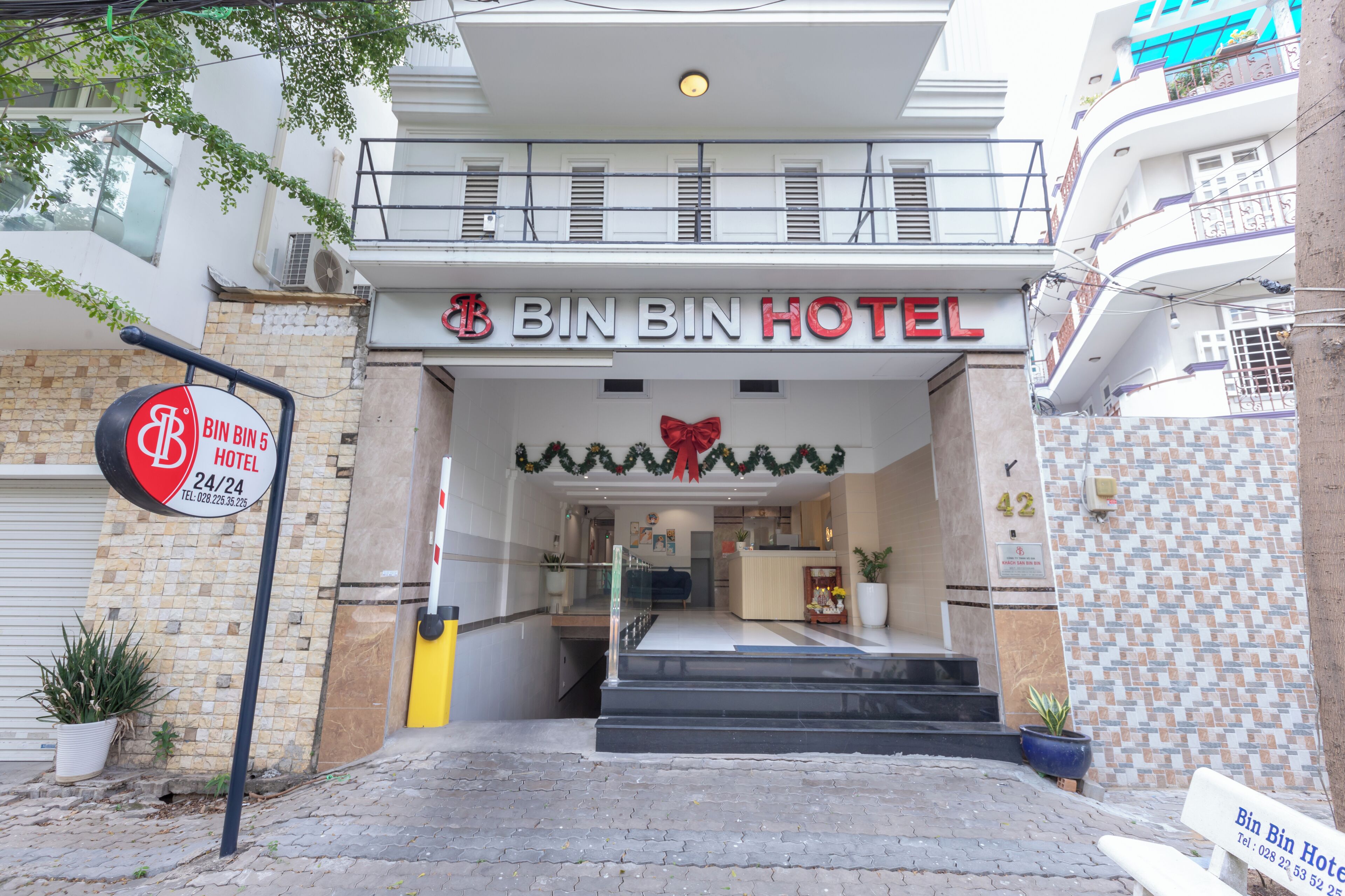 The exterior of Bin Bin Hotel with a clear entrance, a reception desk, and a staircase leading to the lobby.