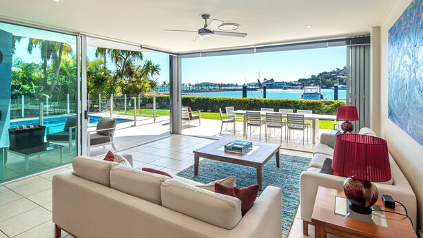 A spacious living room with a large glass door leading to an outdoor patio.