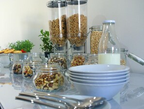 Una mesa de buffet con varios recipientes de comida y utensilios.