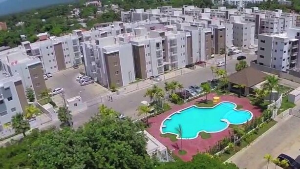 A residential area with modern apartment buildings, a central swimming pool, and surrounding greenery. - HeimatDorado R.D. your pleasant stay (Santiago de los Caballeros)