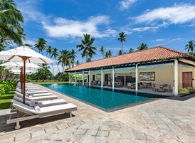 Una piscina al aire libre, sombrillas, sillones reclinables de piscina