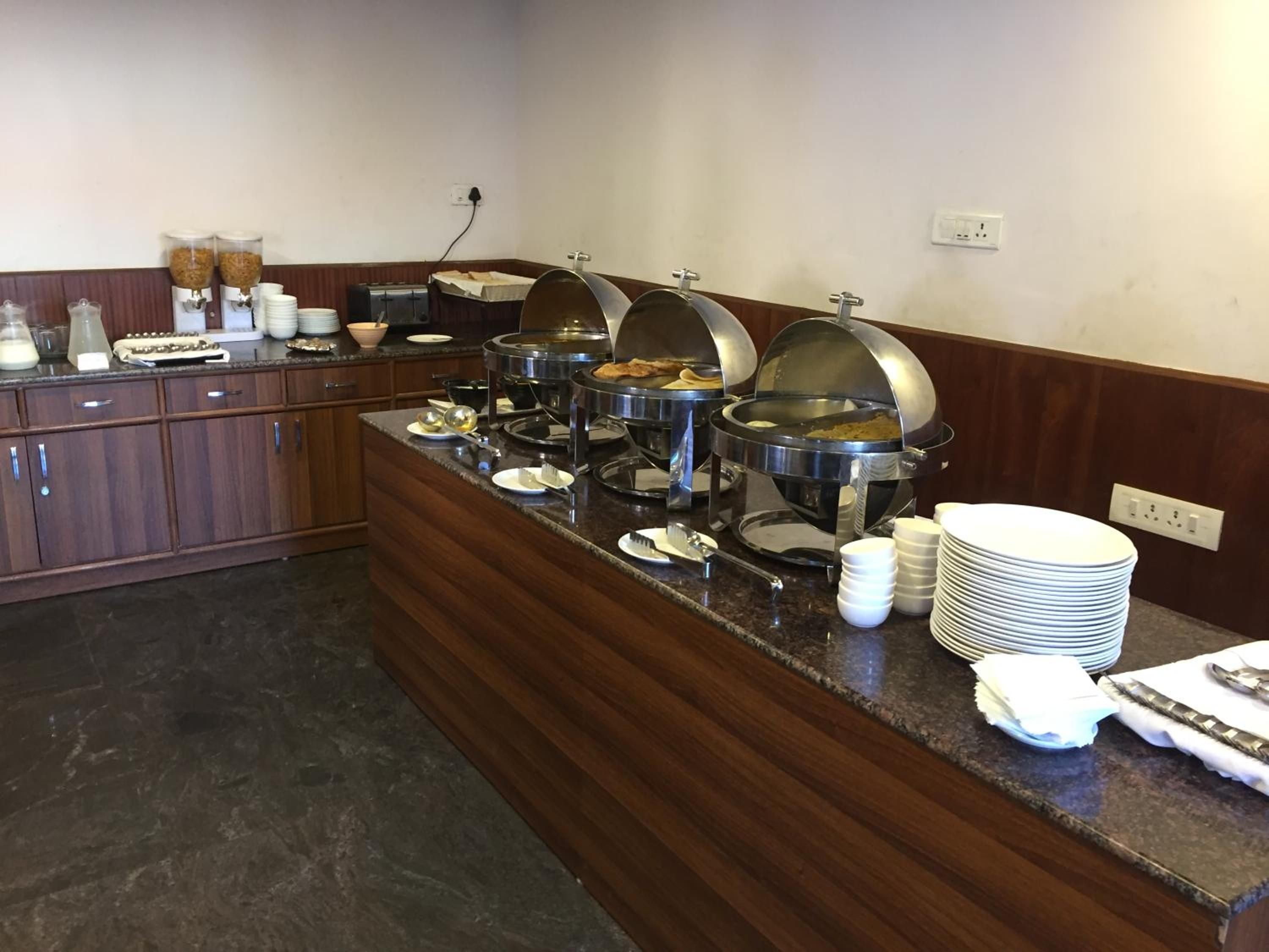 A buffet setup with multiple food stations, including a coffee station and various food containers.