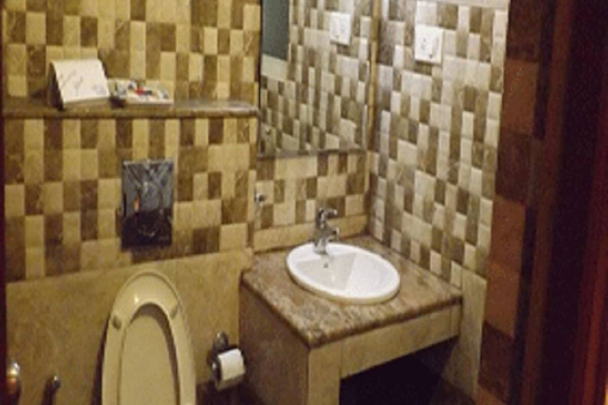 Un baño con inodoro, lavamanos y paredes con azulejos.