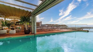 An indoor infinity pool with lounge chairs and a bar area. - Hotel & Spa La Residencia Puerto (Tarifa)