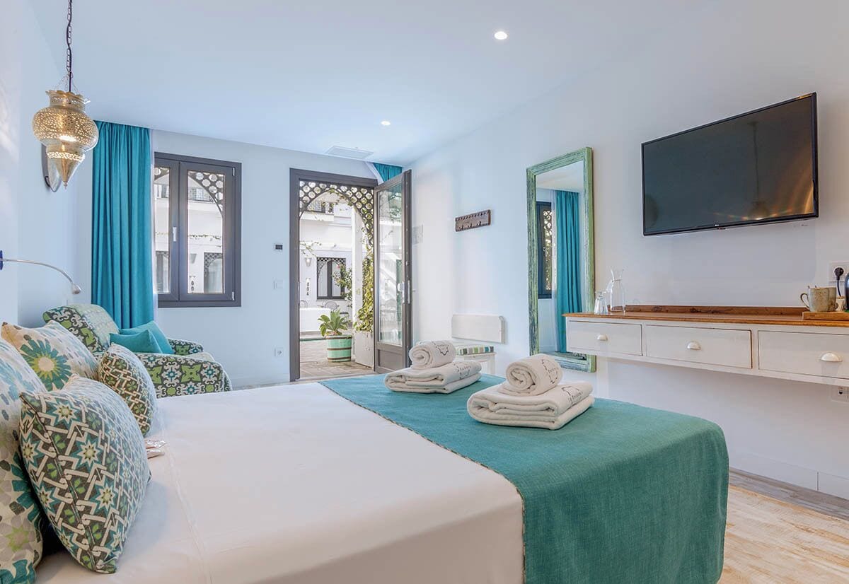 Une chambre d’hôtel avec un lit, une télévision, un miroir et une vue sur l’extérieur.