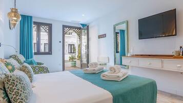 Une chambre d’hôtel avec un lit, une télévision, un miroir et une vue sur l’extérieur.