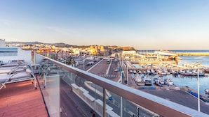 A balcony with a view of a harbor, a road, and buildings in the background. - Hotel & Spa La Residencia Puerto (Tarifa)