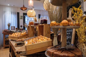 Un buffet proposant une variété de produits de boulangerie et un menu écrit à la craie.