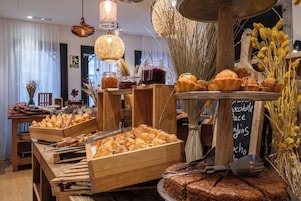 A buffet setup with various baked goods and a chalkboard menu.