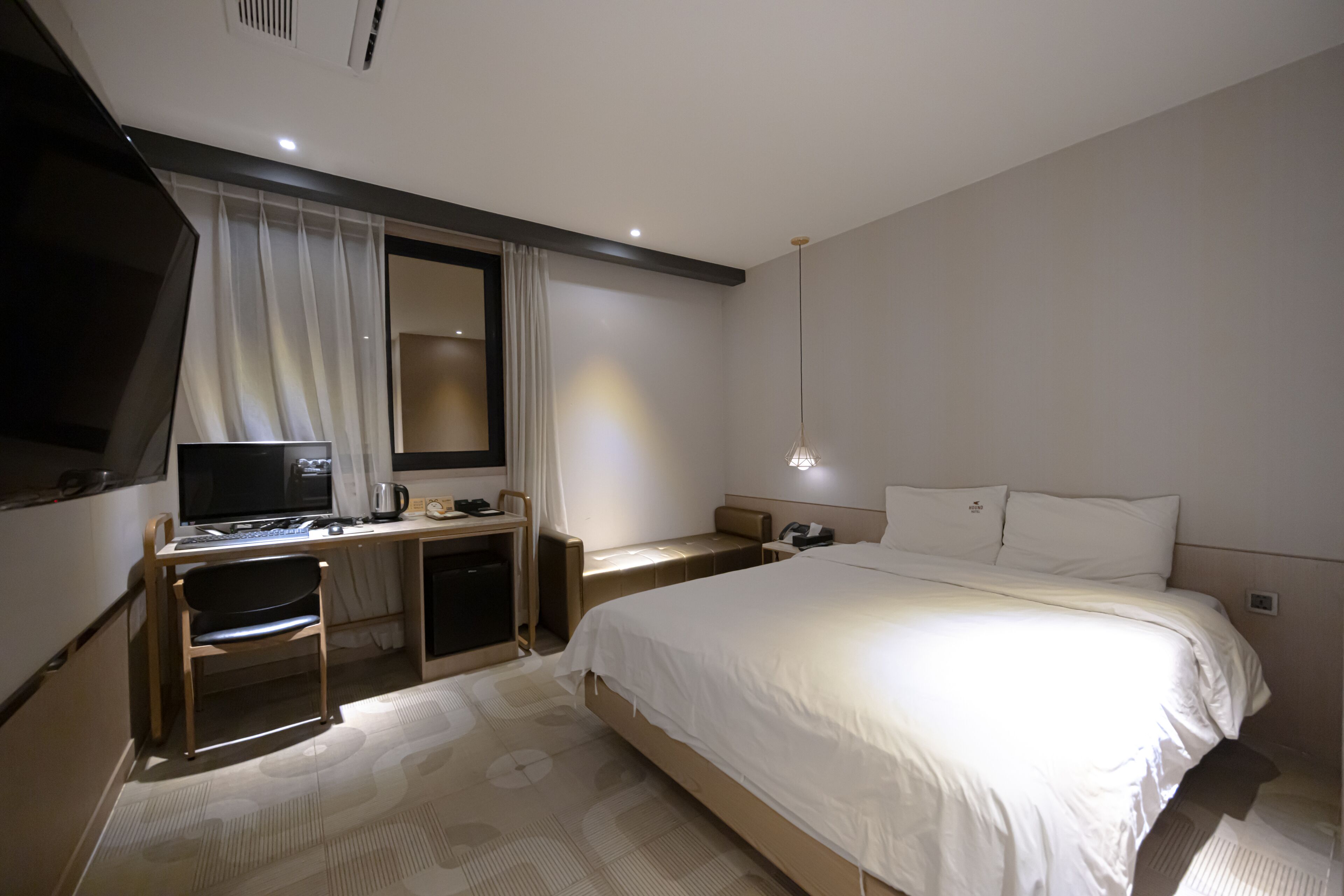 Une chambre d’hôtel équipée d’un lit, d’un bureau, d’une chaise et d’un téléviseur.