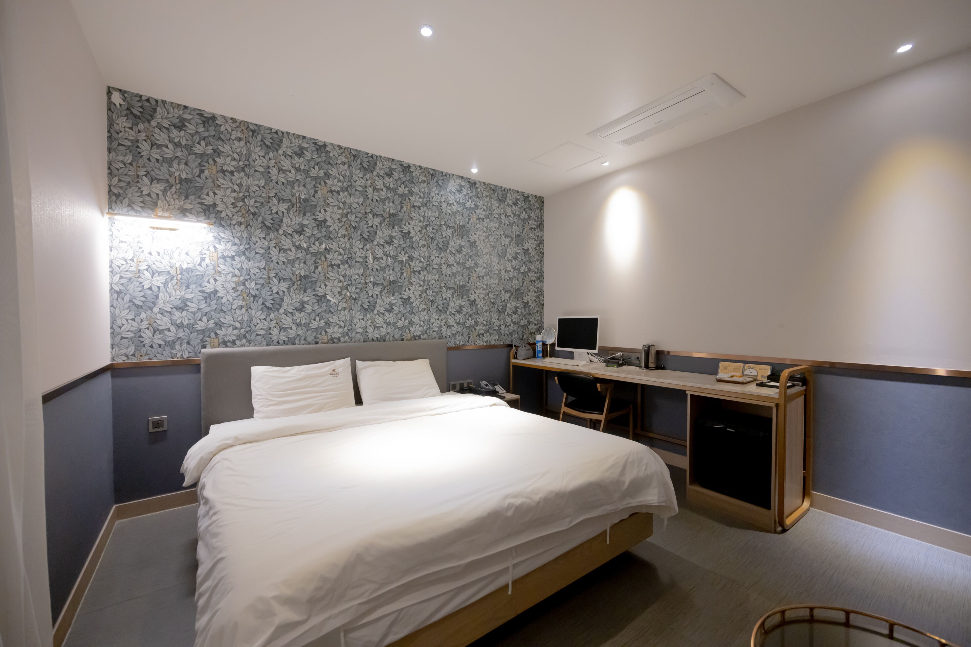 Une chambre d’hôtel équipée d’un lit, d’un bureau, d’une chaise et d’une petite kitchenette.