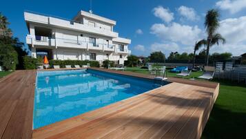 Una piscina al aire libre de temporada, tumbonas